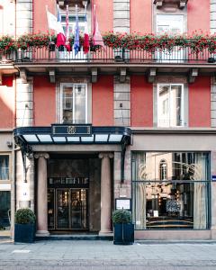 eine Gebäudefassade mit Flaggen auf einem Balkon in der Unterkunft Maison Rouge Strasbourg Hotel & Spa, Autograph Collection in Straßburg