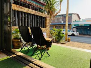 a couple of chairs sitting on top of grass at Hee Pee hostel Buriram in Sathani Buriram