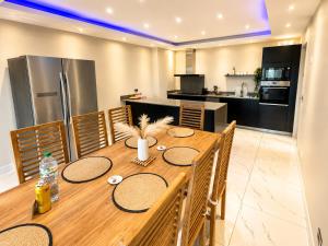 a kitchen and dining room with a wooden table at Oaks Penthouse - Flic en Flac in Flic-en-Flac