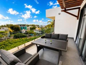 a patio with a table and chairs on a balcony at Oaks Penthouse - Flic en Flac in Flic-en-Flac