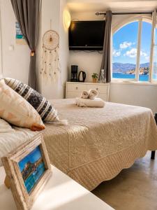 a bedroom with a bed and a large window at Horn Agios Nikolaos in Agios Nikolaos