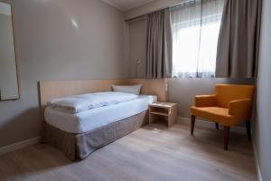 a small bedroom with a bed and a chair at Rebhan's Klassik in Stockheim +16 photos