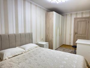 a bedroom with a large bed and a desk at Apartment in Almaty +6 photos