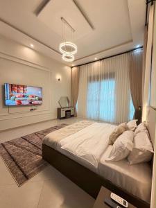 a bedroom with a large bed and a tv at The Serene Sanctuary in Kampala +13 photos