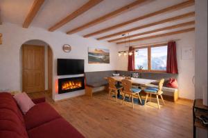 a living room with a couch and a table and a fireplace at Binterhof in Castelrotto