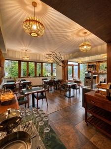 a restaurant with tables and chairs and chandeliers at Ioana Boutique Hotel in Sinaia