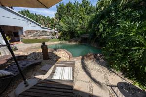 a pool in a yard with a bench and an umbrella at Beyond Cui Bono - Travel Addo Group in Sunland