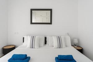 a white bed with two blue pillows on it at Edf España Suites Mijas in Mijas +16 photos