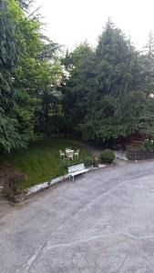 a white bench sitting in the middle of a park at Smith's house in Borgo San Dalmazzo