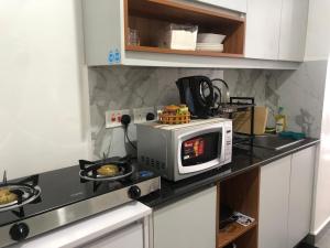 a microwave sitting on a counter in a kitchen at Tsavo Stanley, Kiambu La Mayan in Kiambu