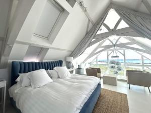 a bedroom with a large bed with a blue headboard at Doleen Quay House in Ballyconneely