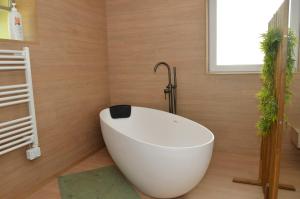 a white bath tub in a bathroom with wooden walls at Horizon d'or in Profondeville