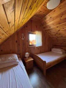 a bedroom with two beds in a wooden cabin at Promyk in Sarbinowo