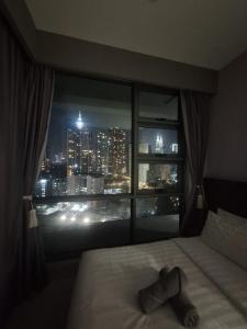a bedroom with a view of a city from a window at Robertson Luxury Apartment in Kuala Lumpur