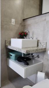 a bathroom with a white sink and a counter at Lindo Studio no Centro de Poços de Caldas in Poços de Caldas +20 photos