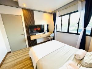 a bedroom with a bed and a flat screen tv at Endless Summer Seafront - 1BR Beach Resort Condo in San Juan
