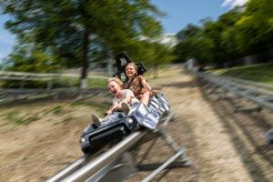 a woman and a child riding on a roller coaster at Apartamenty Solina 67 in Solina