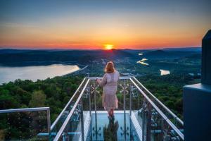 a woman standing on top of a viewing platform with the sunset at Apartamenty Solina 67 in Solina
