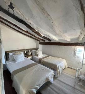 a bedroom with two beds and a ceiling at Ca'n Baster 1878 in Juncosa