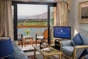 a living room with a television and a large window at Sonesta St. George Hotel - Convention Center in Luxor