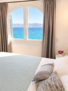 a bedroom with an ocean view from a window at Horn Agios Nikolaos in Agios Nikolaos