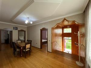 a dining room with a table and chairs and a window at Gabala White House in Gabala