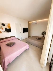a bedroom with two beds and a flat screen tv at B&B LE MAGNOLIE in Termoli +22 photos