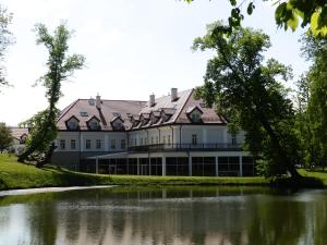 a large building with a pond in front of it at Pałac Żelechów Spa & Wellness in Żelechów