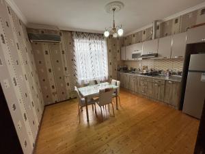 a kitchen and dining room with a table and chairs at Gabala White House in Gabala +6 photos