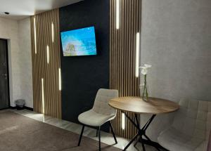 a room with a table and a tv on a wall at Готель River House in Uman