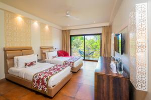 a hotel room with two beds and a television at The Ivy Anjuna in Anjuna +39 photos