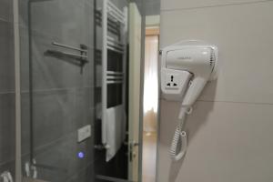 a blow dryer in a bathroom next to a shower at Prime Heaven in Chiatʼura +39 photos