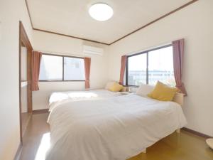 two beds in a room with two windows at Fuji Hyakkei - Dream Bridge in Fuji