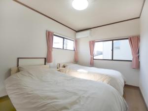 two beds in a room with two windows at Fuji Hyakkei - Dream Bridge in Fuji