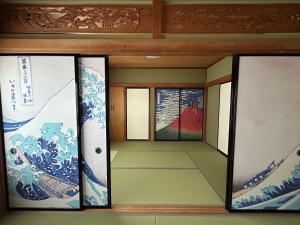 a room with three paintings on the wall at Fuji Hyakkei - Dream Bridge in Fuji