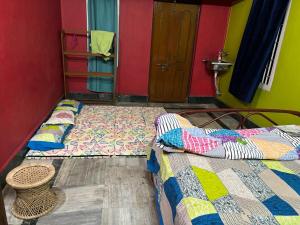 two twin beds in a room with a door at Real City Homestay in Guwahati