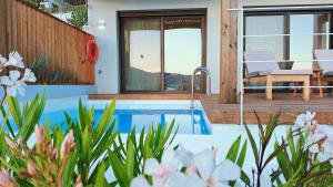 a pool in the backyard of a house with flowers at Villa Tulivu in Paleros