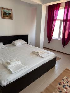 a bedroom with a bed with two towels on it at Hotel Azur in Costinesti