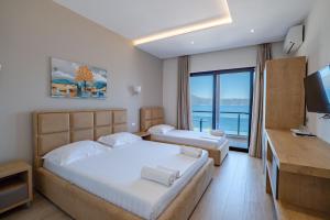 a hotel room with two beds and a television at Hotel Roalb in Vlorë +82 photos