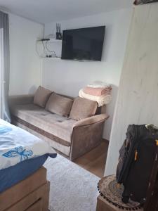 a living room with a couch and a flat screen tv at Radovići,Luštice in Radovici +30 photos