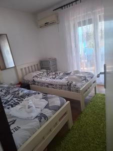 a bedroom with two beds and a window at Radovići,Luštice in Radovici