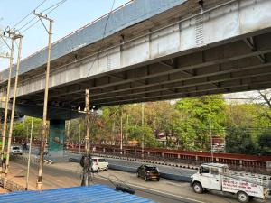 a bridge over a street with cars and trucks at Real City Homestay in Guwahati
