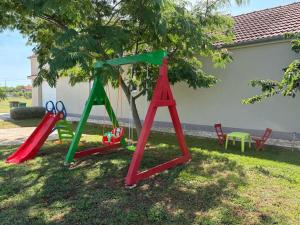 two swings in a yard with a tree at Kuća za odmor - Snowwhite in Smoković