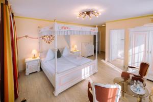 ein Schlafzimmer mit Himmelbett, Tisch und Stühlen in der Unterkunft Hotel Speeter in Weisenheim am Berg + 82 Fotos
