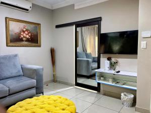 a living room with a couch and a television at RAMATA GUEST HOUSE in Pretoria