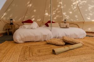 two beds in a canvas tent with shoes on the floor at Paradise Glamping in Saint Vincent