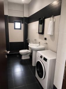 a bathroom with a washing machine and a sink at Vila New Ksamil in Ksamil