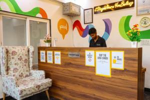 a man standing behind a counter with a chair at Coco House in Greater Noida