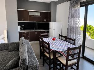 a kitchen and dining room with a table and a couch at Vila New Ksamil in Ksamil +34 photos