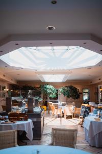 a restaurant with tables and chairs and a large ceiling at Hotel Landhaus Wörlitzer Hof in Oranienbaum-Wörlitz